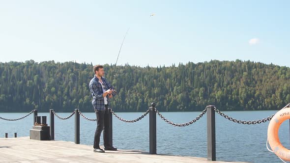 Fisherman Standing on Riverside and Trying To Catch Fish