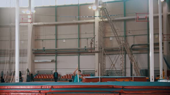 Pole Vaulting - Athlete in Blue t Shirt Is Running and Jumping Over the Bar