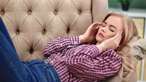 Unhappy Young Woman Massaging Temples Having Migraine Lying on Sofa