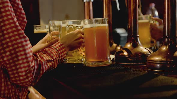 Waiter Grabs HUGE Glasses of Beer to Serve in a Bar at Night Slow Motion