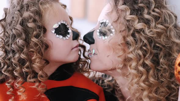 Mom and Daughter Is Halloween Costumes Looking at Each Other