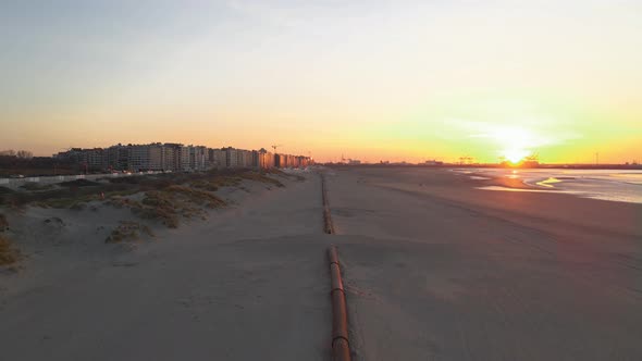 Coast pipeline sunset with seaport at horizon (4K)