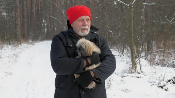 Old Man with Beard Holds Furry Trembling Dog in Arms