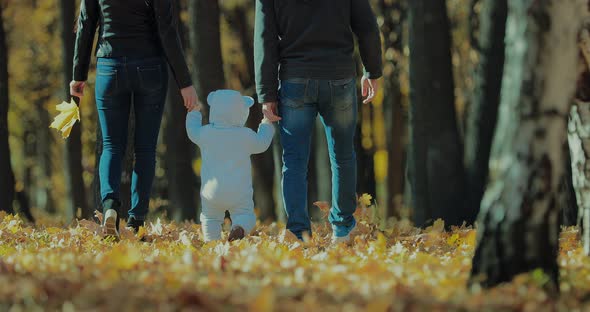 Happy Family Walking in the Park on an Autumn Day