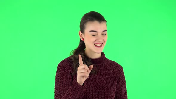 Girl Listens Carefully, Threatens with a Finger Seductively. Green Screen