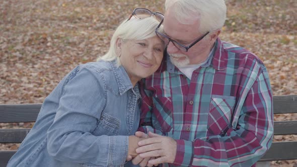 Elderly European Couple Sitting on the Bench and Talking