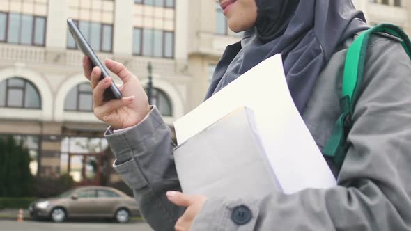 Muslim Girl Using Phone, Waiting for Friends Near College, Education in Europe