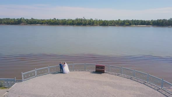 Newlywed Couple Looks at River From Viewpoint Aerial View