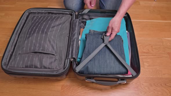 Close up view of man packing clothes in luggage before traveling. Sweden.