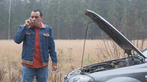 Sad Man Standing Near the Broken Car and Calling Car Assistance Services.