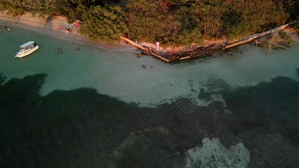 Flying drone backwards on beach with PUERTO RICO FLAG during sunset time.