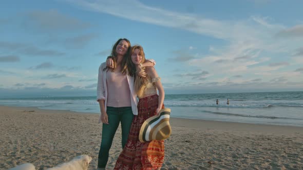 Mother and Daughter at the Beach with Their Dog Hugging and Smiling at Camera