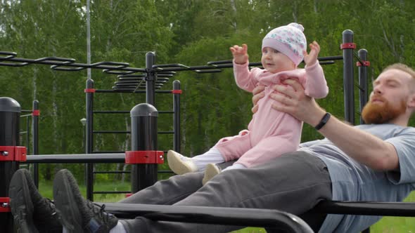 Multitasking Caucasian Dad Exercising while Walking with Baby