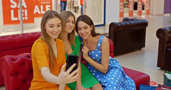 Portrait Girlfriends Take a Selfie in the Supermarket Smile at the Phone Camera and Wave