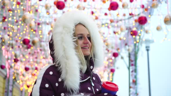 Girl Walks on the Decorated Winter Street