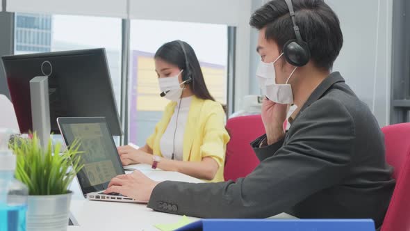 Group of Asian business call center people wear face mask and working in office with new normal.