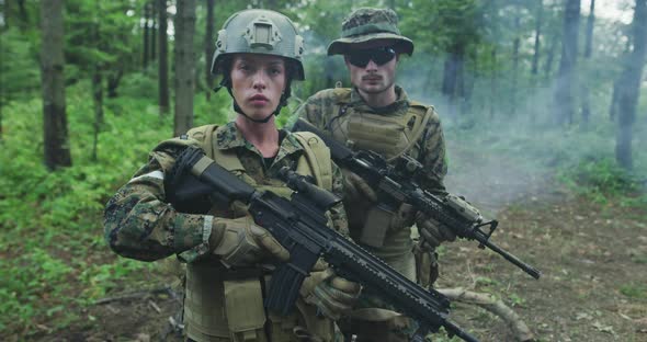 Squad of Soldiers Patrolling Across the Forest Area Team with Male and Female Soliders in Dense