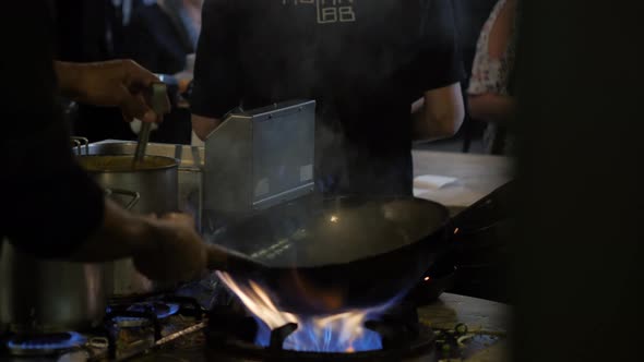 Chinesse Chief Cook Cooking on the Wok Pan with Flambe on the Asian Restaurant Kitchen Pasta Seafood