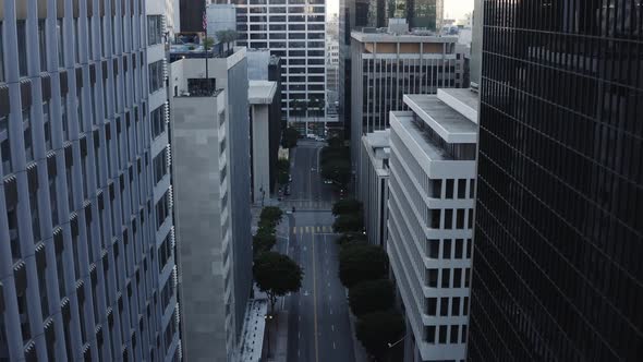 Fly up between skyscraper in downtown LA with the deserted street below because of the shelter in pl