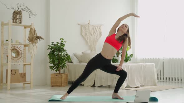 Young Athletic Woman in Leggings and Top Does Stretching Exercises