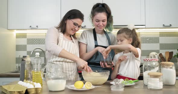 Mother Teaches Her Two Daughters Cook Muffins at Home in Kitchen