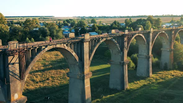 Enormous Stone Bridge with a Woman Running Along It