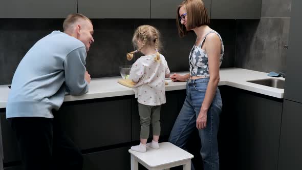 Young Mom with Little Daughter Cooking Dinner