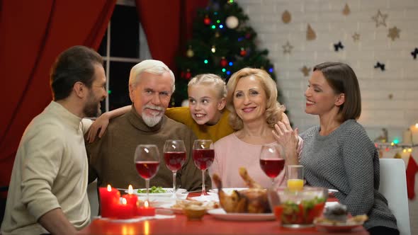 Big Family Hugging, Smiling and Looking to Camera at Christmas Dinner, Portrait