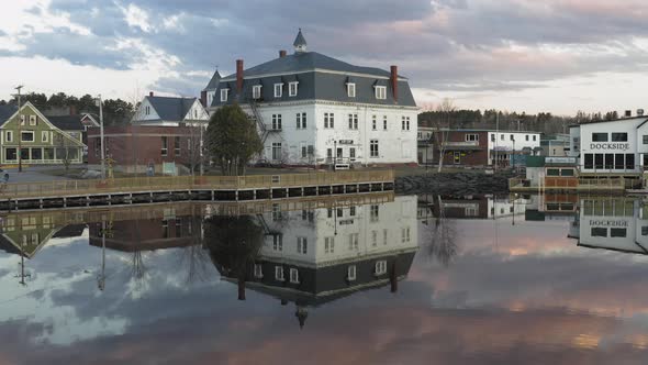 Colorful clouds and a quiet downtown reflecting in a calm lake AERIAL PULL BACK