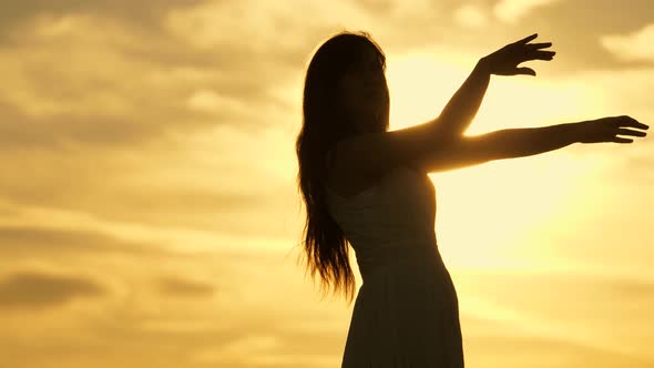 Happy Girl Dancing at Sunset. Free Girl Resting at a Party in the Warm Sun. Beautiful Movements in