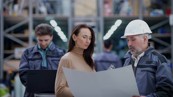 Troubled Beautiful Young Woman and Handsome Senior Man Discussing Delivery Time in Industrial