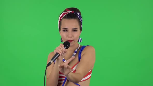 Portrait of Beautiful Girl in a Swimsuit Is Singing Into a Microphone and Moving To the Beat of