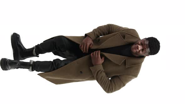 Young Black Male Being a Little Bent While Moving Around and Pointing Fingers White Background