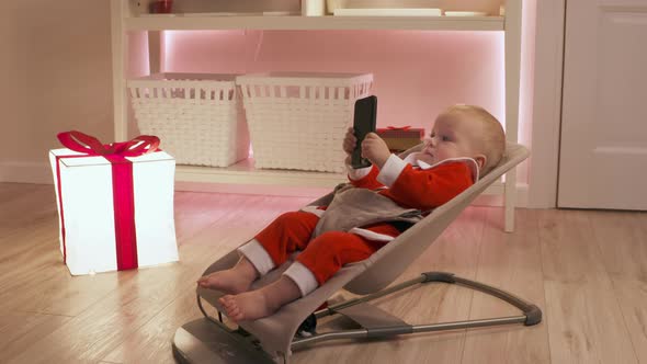 Child Dressed in Santa Claus Having Fun on New Years Eve Using Smartphone Happy Kid Celebrates His