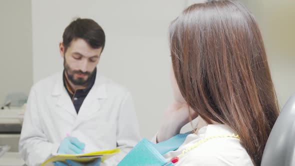 Woman with Toothache Looking to the Camera Sitting in Dental Chair