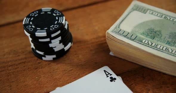 Close-up of playing cards, dollar and casino chips on poker table