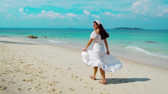 slow-motion of cheerful woman walking on the sea beach at Koh MunNork Island, Rayong, Thailand