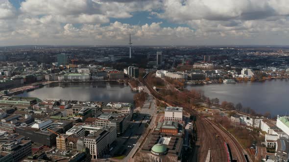 Wide Aerial View of Car and Train Traffic Across Binnenalster Lake with Hamburg Panorama in the