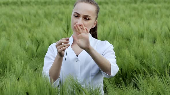 Ecologist in a white coat and glasses examining plants