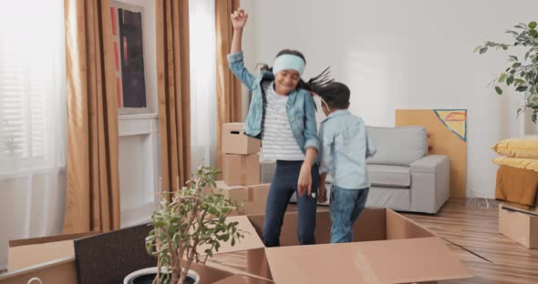 Siblings Play While Moving in Cardboard Boxes New Apartment Renovation Renting House They Hide