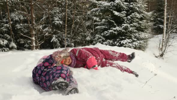 Children Playing In Deep Snow. Little Girls Walking Outdoor At Winter Sunny Day.