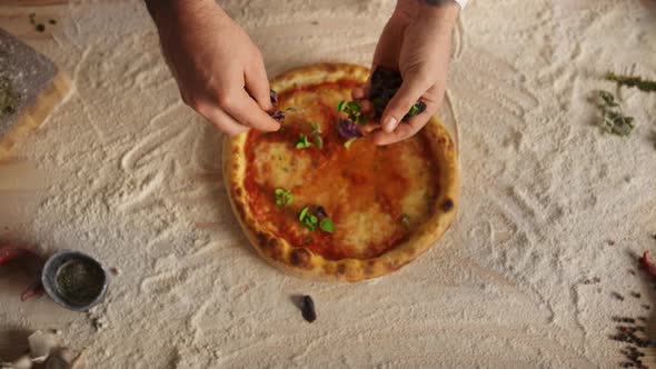 Chef Hands Preparing Recipe Adding Ingredients on Italian Pizza at Restaurant