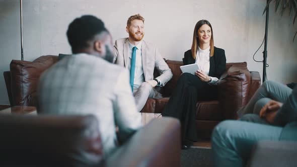 Business people sitting in a hotel lobby and working remotely