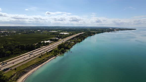 Aerial view of a cars driving on a highway along the Lake Ontario in Canada. Aerial view of a scatte