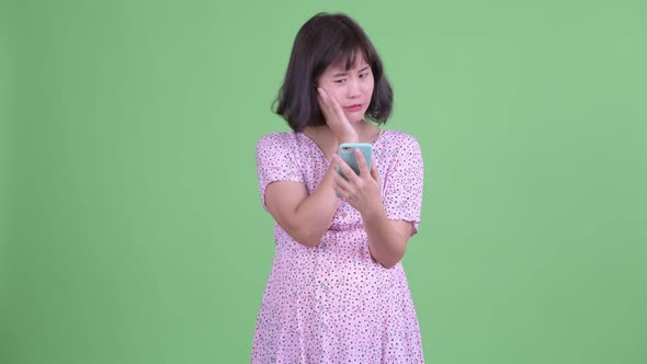 Stressed Asian Pregnant Woman Using Phone and Getting Bad News