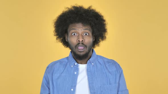 Surprised AfroAmerican Man in Shock on Yellow Background Wondering