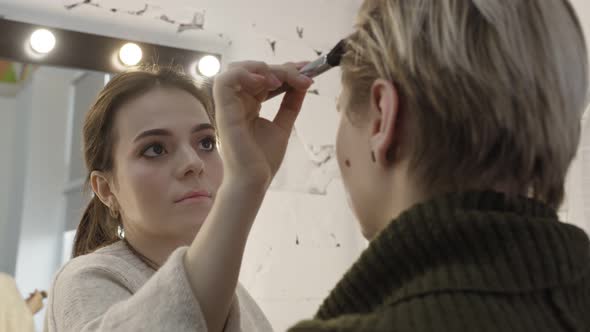 Young Cute Teen Girl Doing Eye Makeup in Beauty Salon