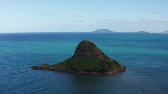 Descending close-up aerial shot of the small island of Mokoli'i, also known as Chinaman's Hat, off t