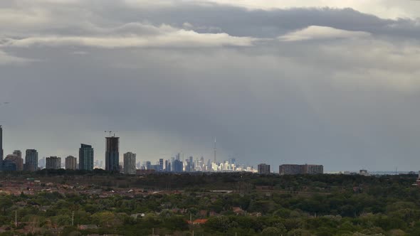 Shifting clouds letting the sun cast beautiful rays over Mississauga and Toronto Skyline. Time-lipse