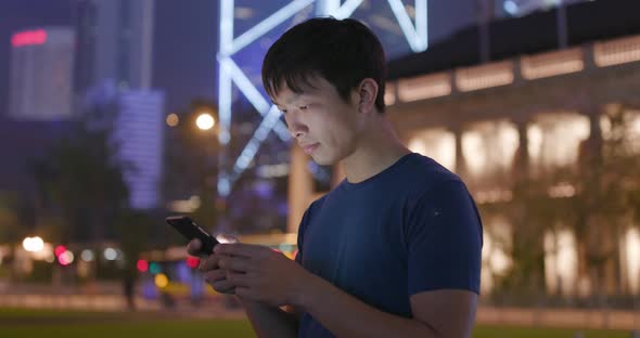 Young Man use of smart phone in city at night